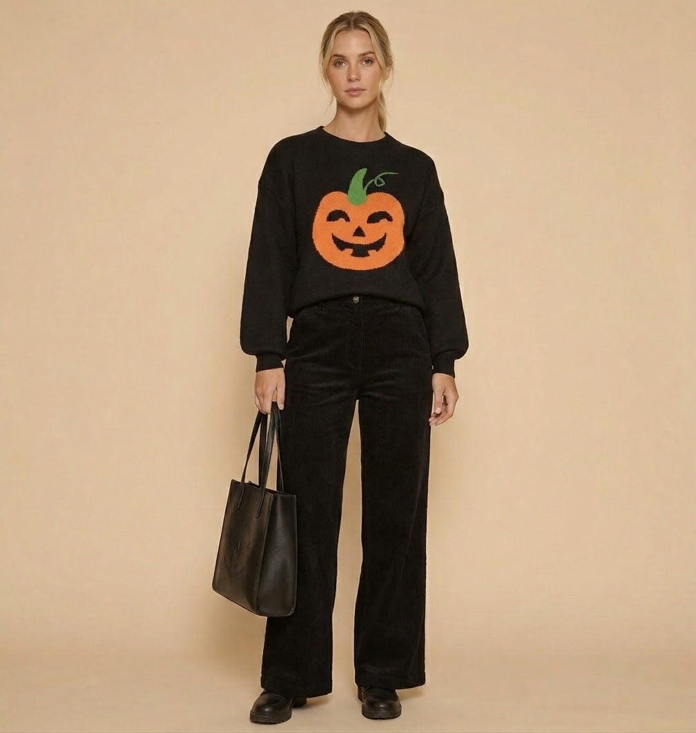 Model wearing the Halloween Pumpkin Sweater, a black knit with an orange jack-o'-lantern face